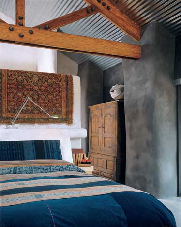 The home’s beautifully handcrafted stone fireplace is a stunning sculptural backdrop for Bennett’s own sculpture, left, and acrylic painting titled, First Mystery, above.